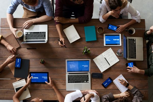 workers sitting around a desk looking at trends