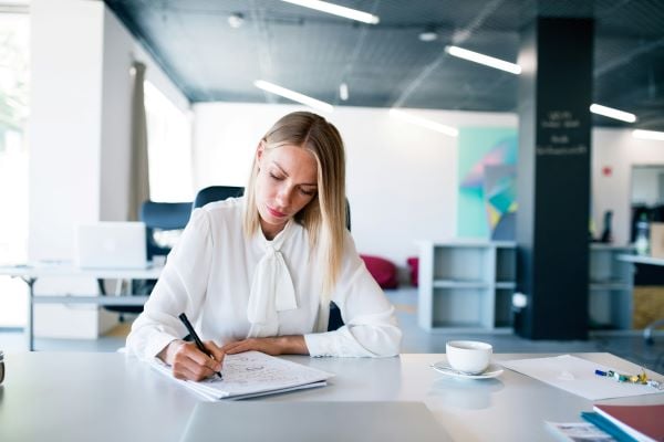 young professional writing at desk